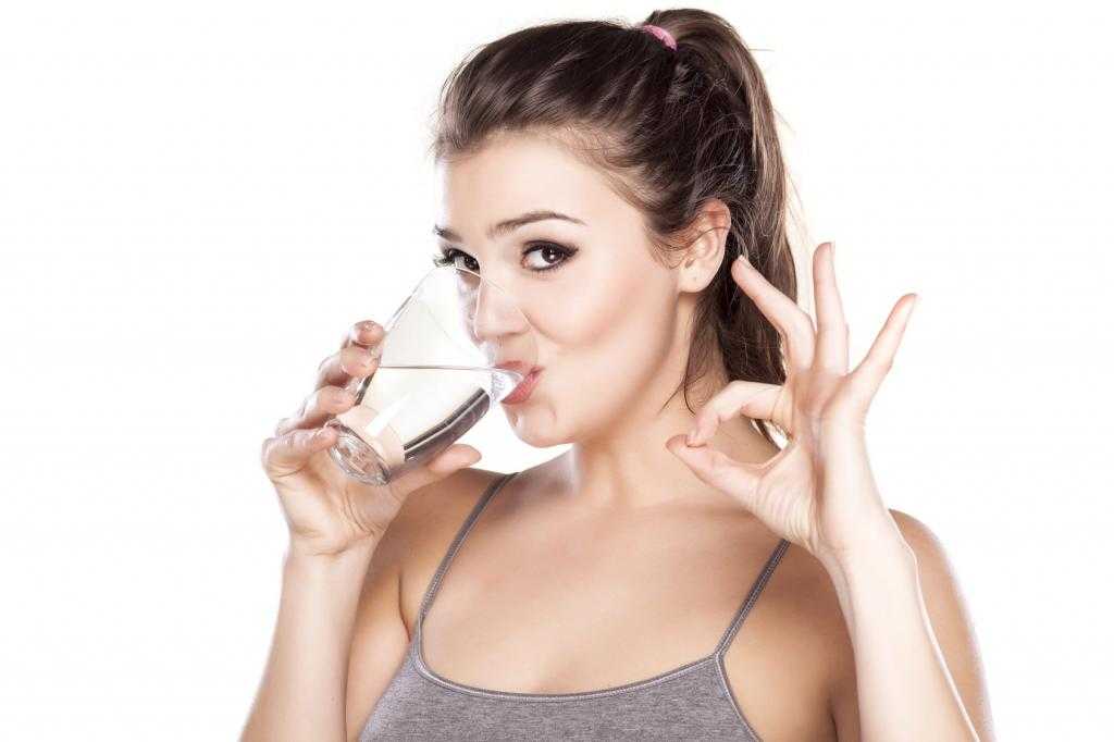 Девушка пьет воду перед УЗИ.