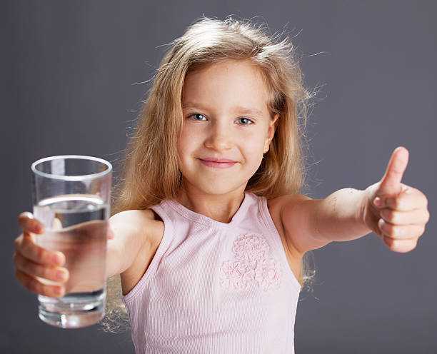 девочка держит стакан с водой