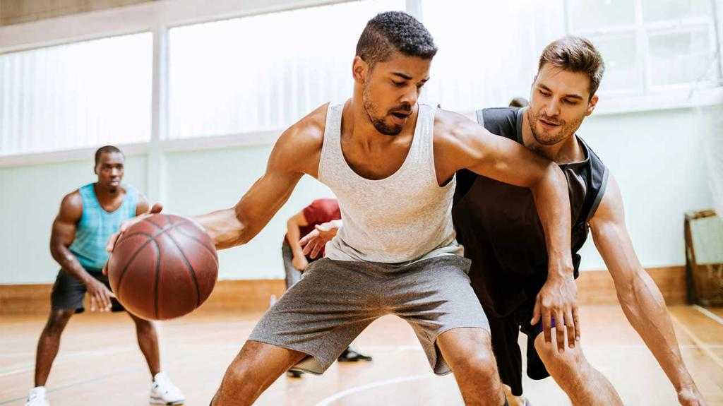 Мужчины играют в баскетбол.